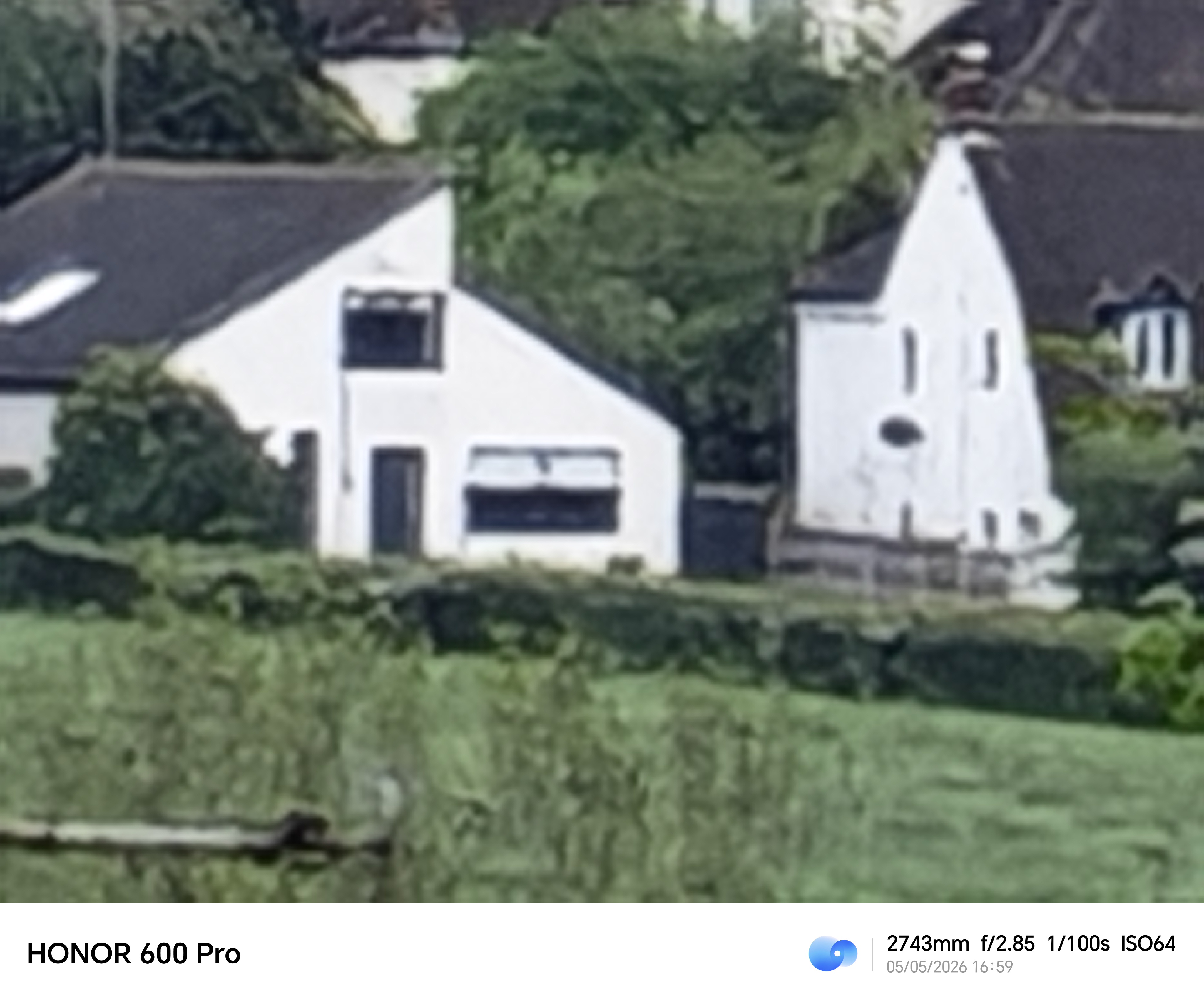 Extreme digital zoom image of distant white houses captured with the Honor 600 Pro