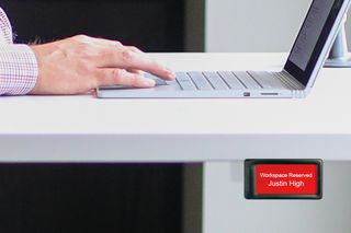 The EPS 27 epaper desk sign under a desk in red, showing it is occupied.