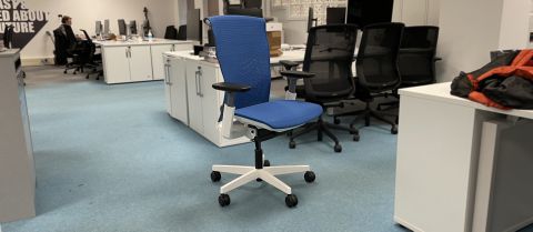 The blue Autonomous office chair, surrounded by generic black office chairs. 