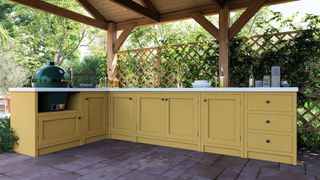 covered outdoor kitchen with yellow cabinetry and BBQ cooking area