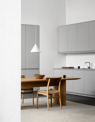 Gray kitchen cabinets with a wooden dining table