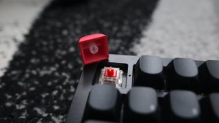 The Keychron Q3 Max gaming keyboard set-up on a desk with the RGB lighting enabled.