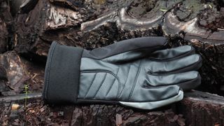 Black waterproof winter cycling gloves on some logs
