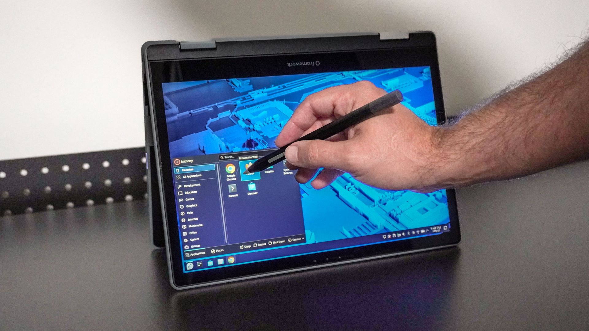 A person using the Framework Laptop 12 in tent mode with a stylus