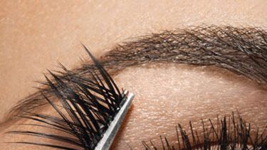 woman applying fake eyelashes