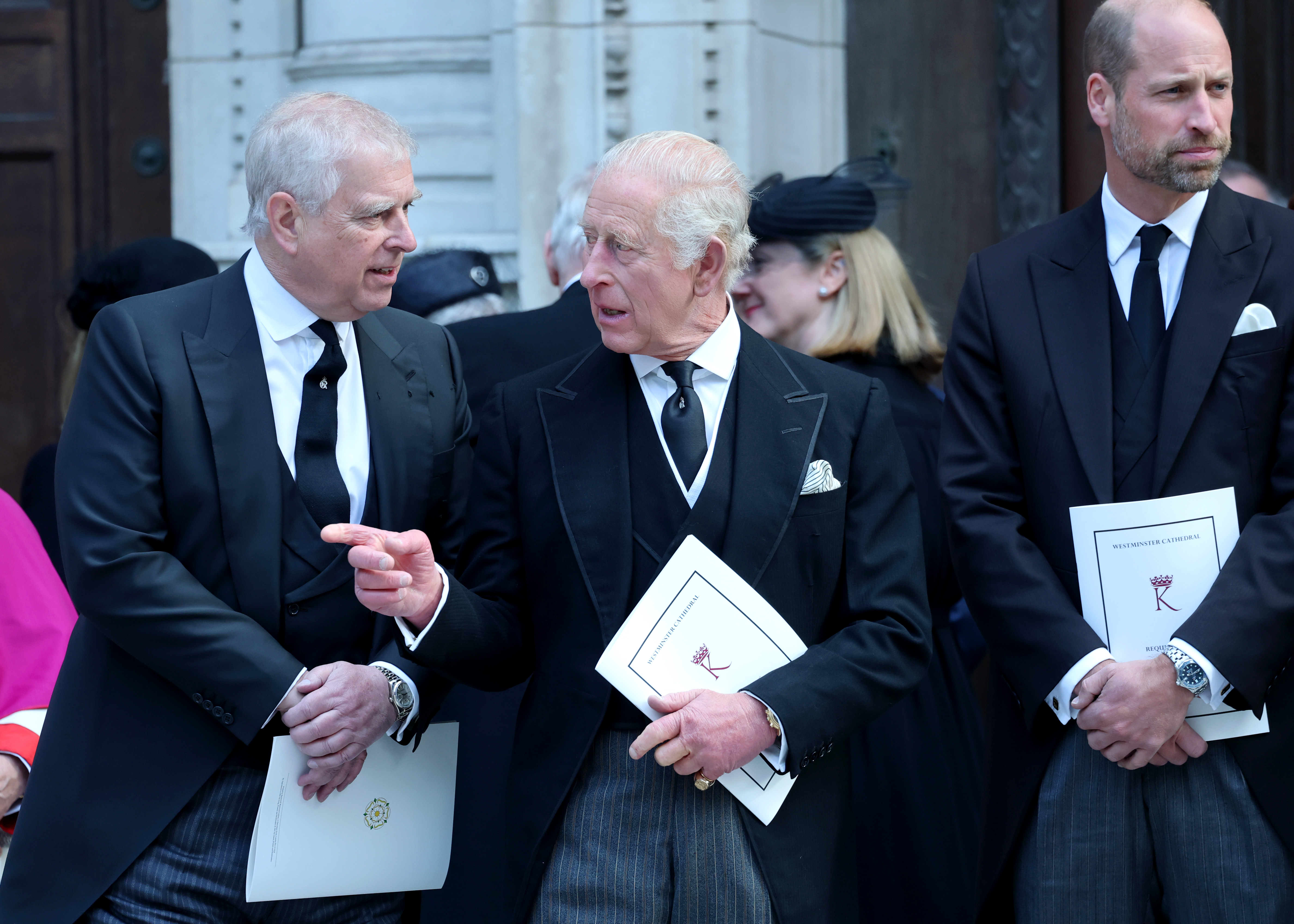Prince Andrew talking to King Charles while Prince William looks away