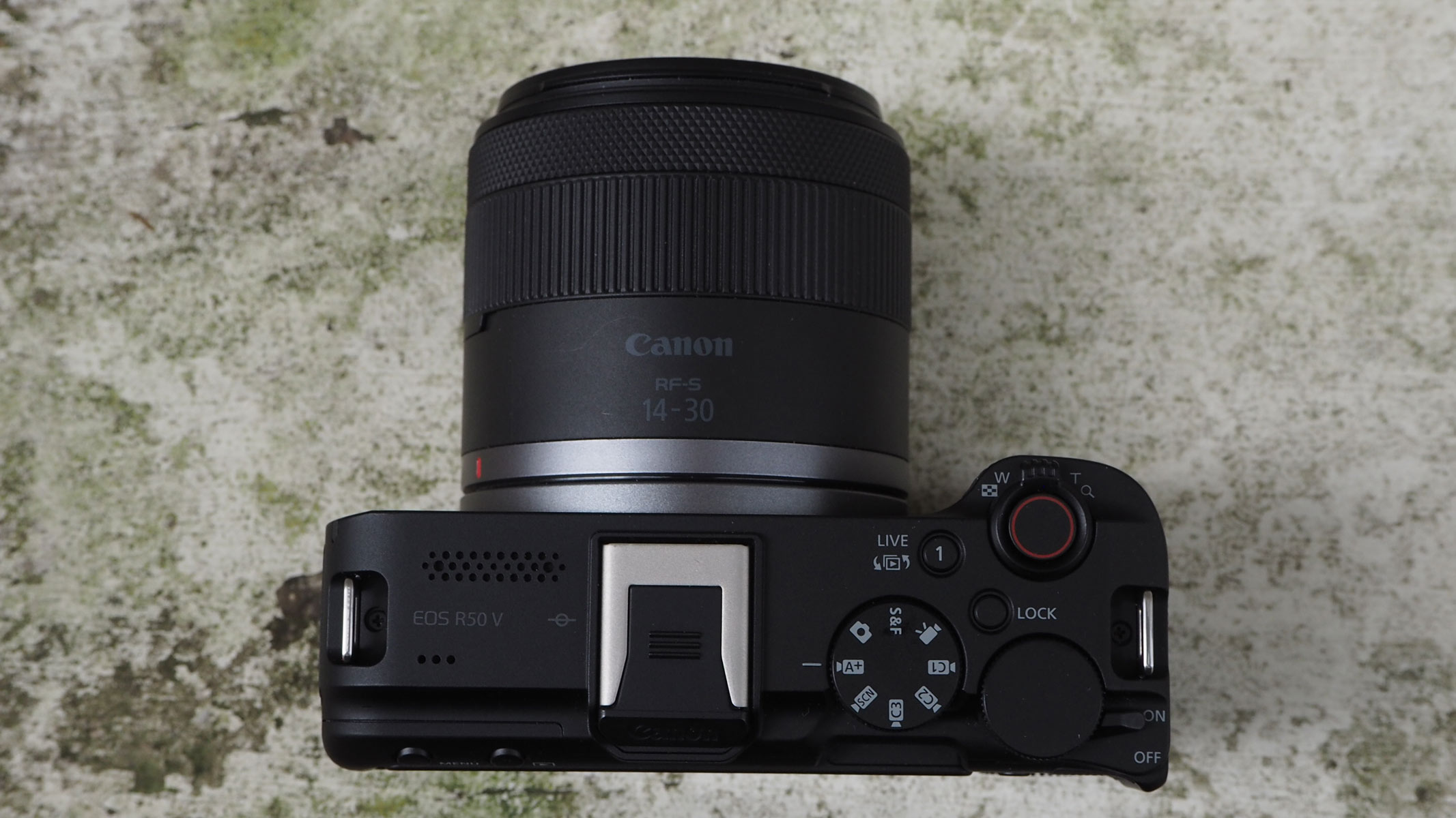 The Canon EOS R50 V on a concrete floor, shot taken from above giving a bird's eye view.