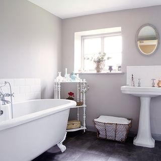 bedroom with grey wall bathtub wash basin and white designed trolley