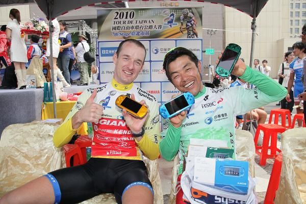 David McCann (Giant Asia) celebrates after his first full day of yellowDavid McCann (Giant Asia) and Takashi Miyazawa (Japan National Team) show off colour-coded PS2's, their prizes for winning the overall, points and Asian rider classifications, respectively.