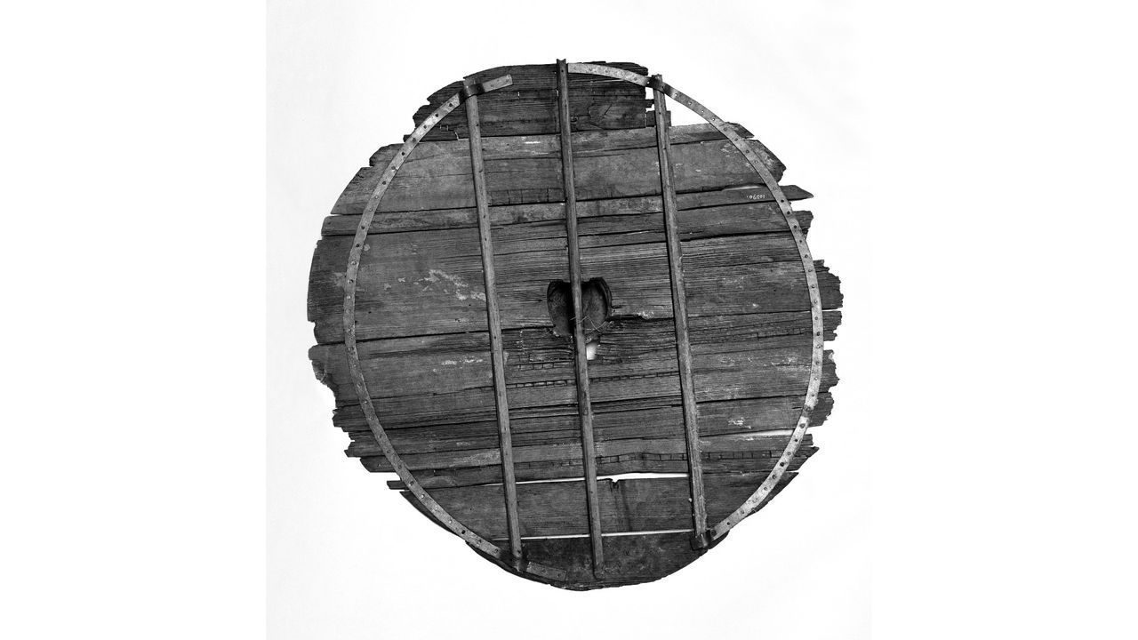 A reconstruction of the back of one of the Gokstad shields, made in the late 19th or early 20th century from original components. A hole for the hand and a handle are behind the central iron boss.
