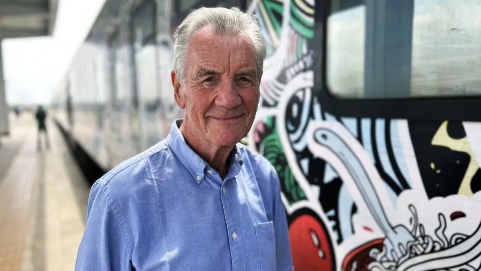 Michael Palin standing before a train in Michael Palin in Nigeria.