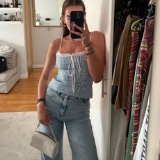 Woman taking mirror selfie with white Amazon and handbag