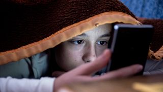 Ragazza che usa uno smartphone prima di andare a dormire