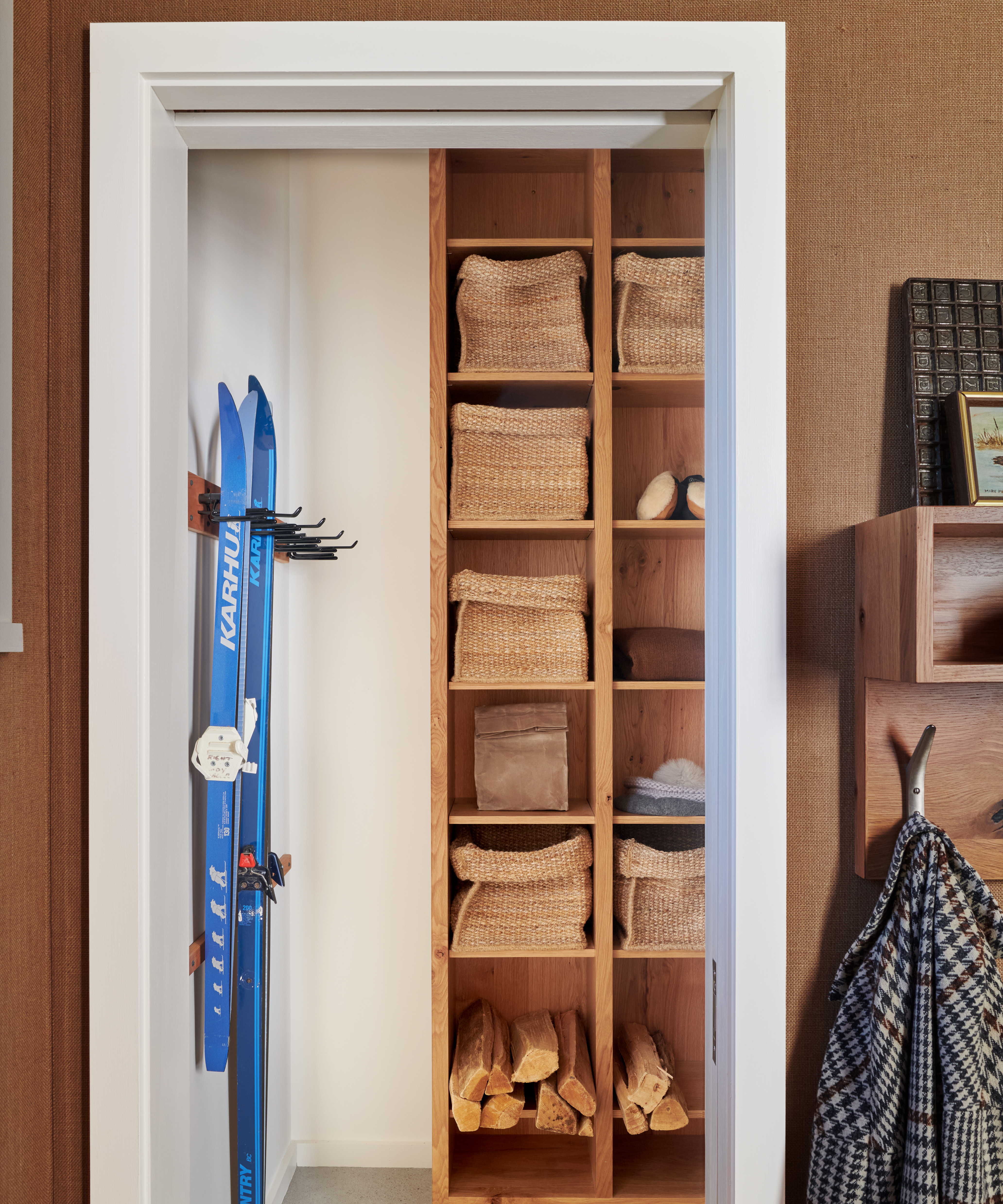 mudroom with skis and storage boxes