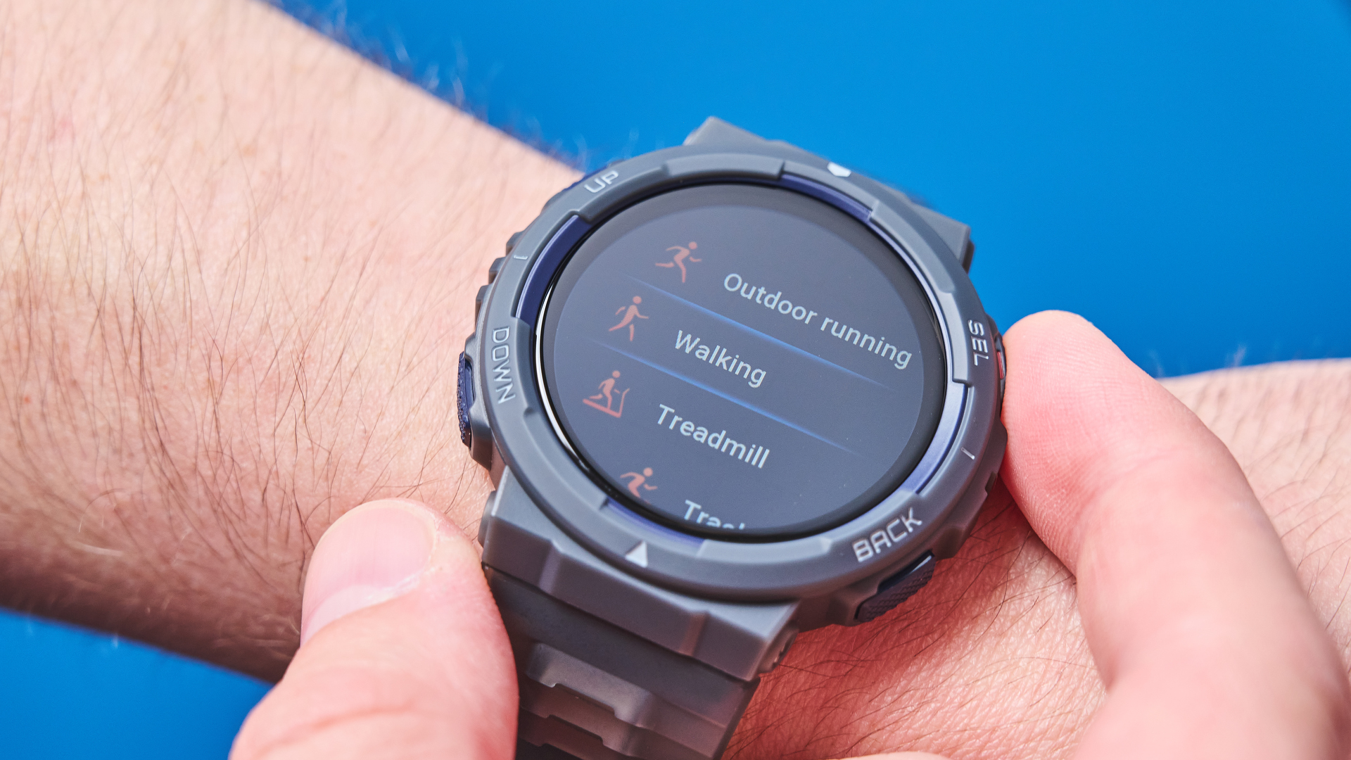 A black and gray Amazfit Active Edge GPS fitness tracker on a person's wrist