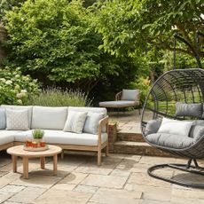 Outdoor sofa and egg chair on patio in garden