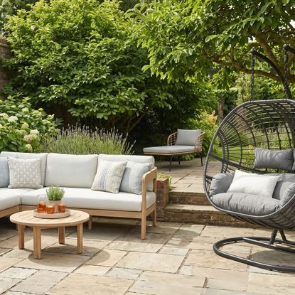 Outdoor sofa and egg chair on patio in garden