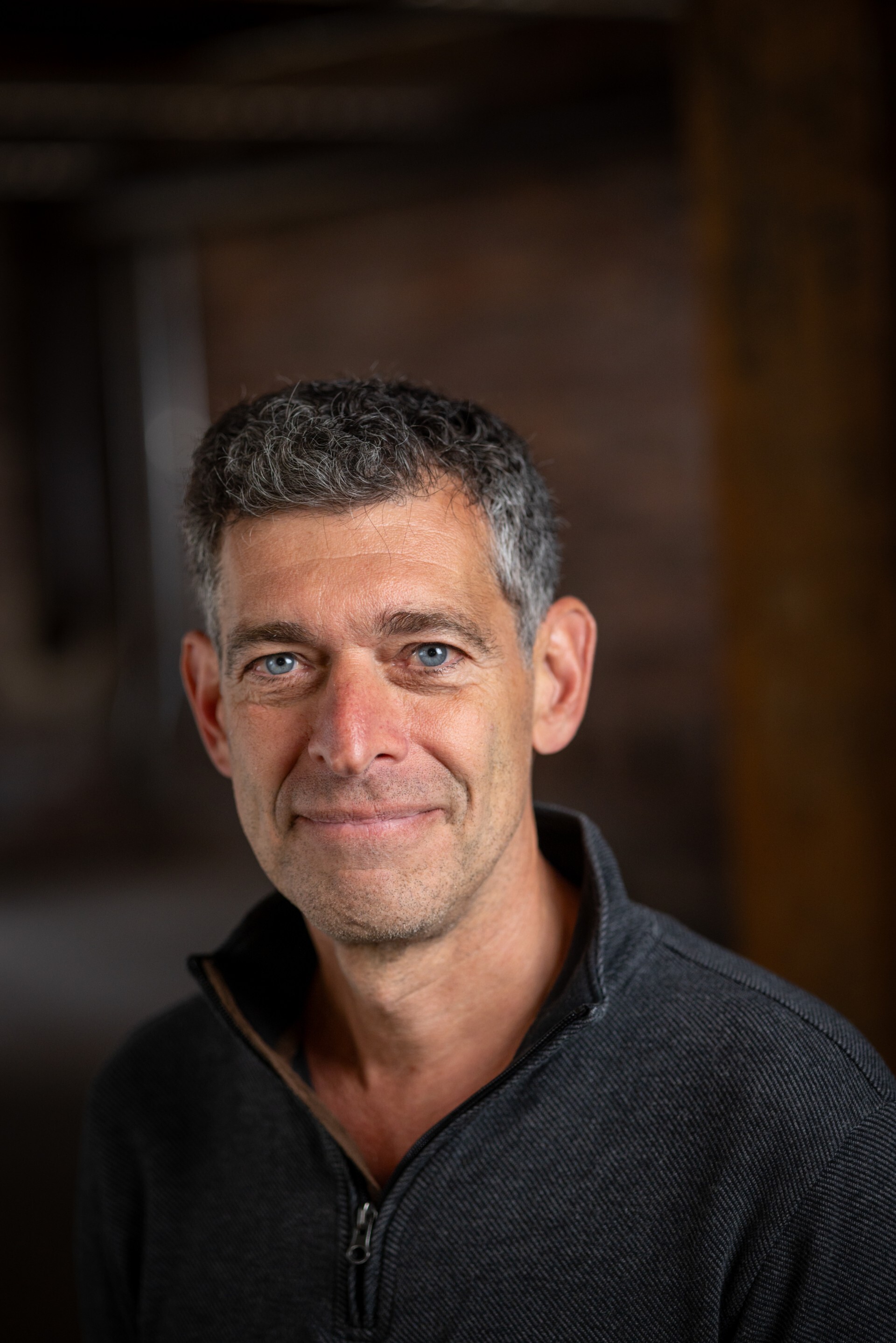 a white man with gray hair in a gray sweater