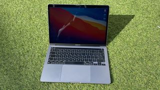 Apple M1 MacBook Pro 13-inch review: image shows Apple M1 MacBook Pro 13-inch on grass