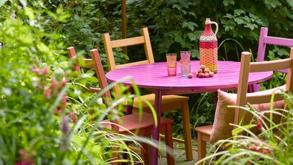 late summer garden ideas: orange and pink painted outdoor dining set 