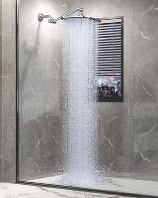 A large square rainfall shoerhead on a lever arch arm in a grey tiled shower