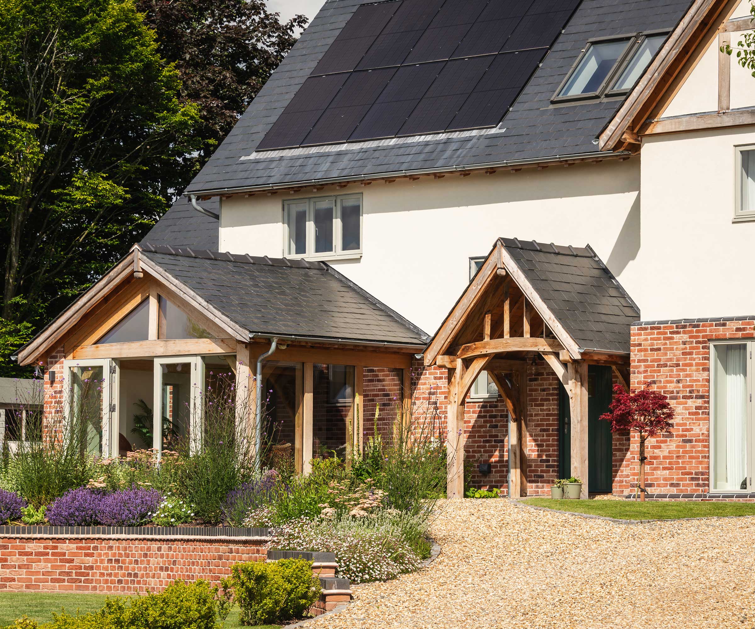 oak frame home with porch, sun room and solar panels on the roof