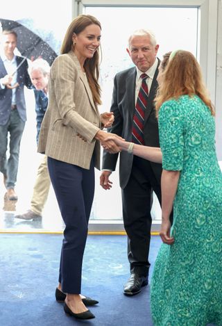 Kate Middleton braves the rain in chic pinstripe blazer