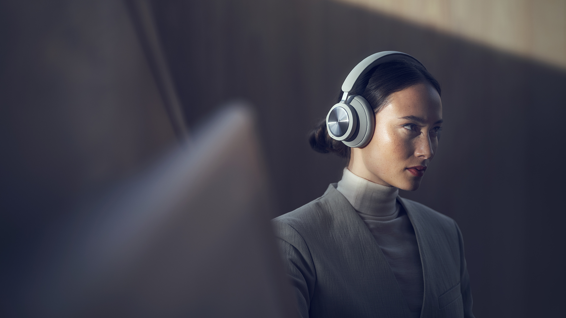A person wearing a white Bang & Olufsen Beoplay Portal gaming headset