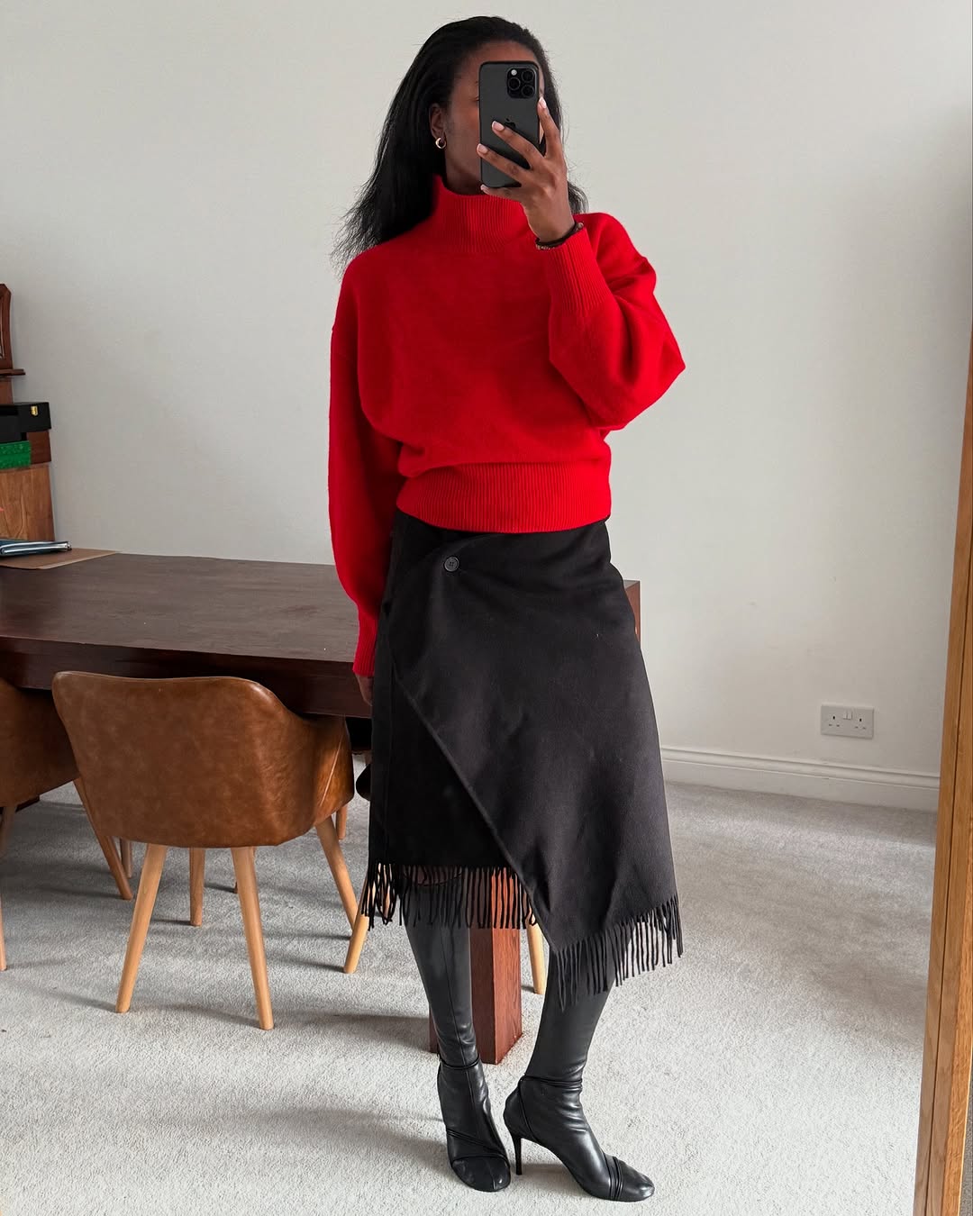 Woman wearing fall boots with skirt outfit 2025.