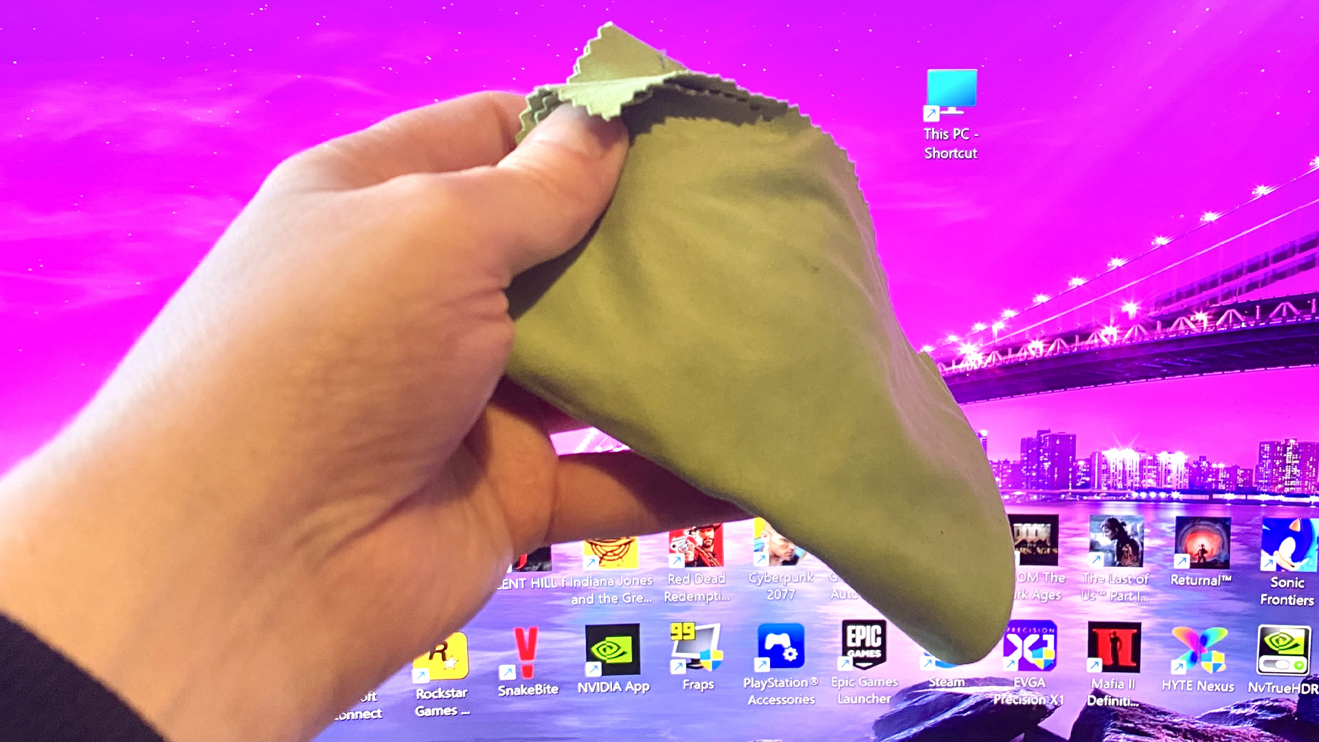 A microfiber cloth cleaning an OLED monitor.
