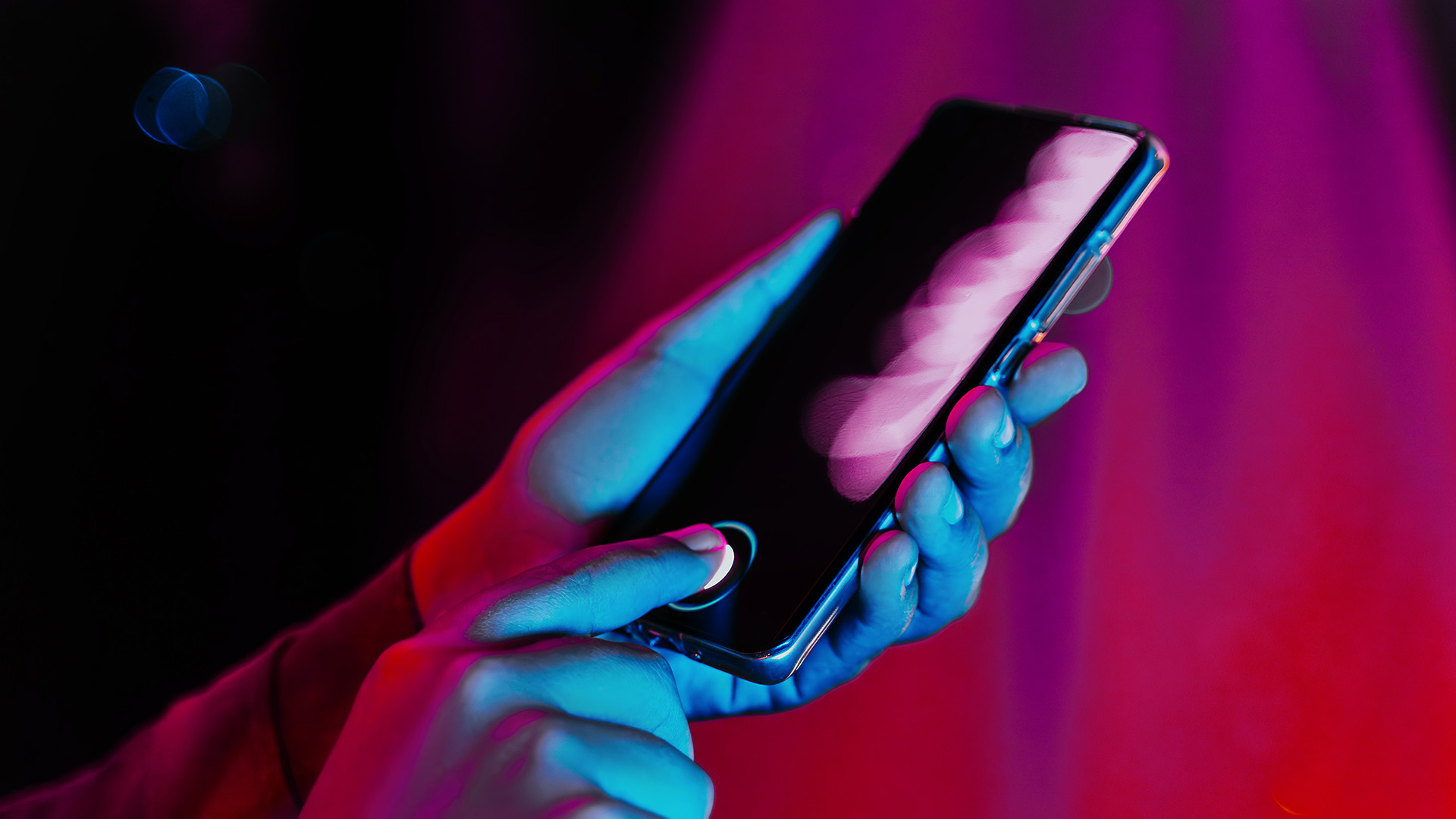 A woman holding a smartphone and using the fingerprint sensor