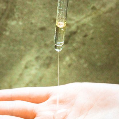 skincare pipette applying product to a hand