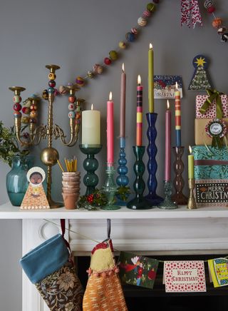 mantelpiece with colourful candlesticks and Christmas decorations