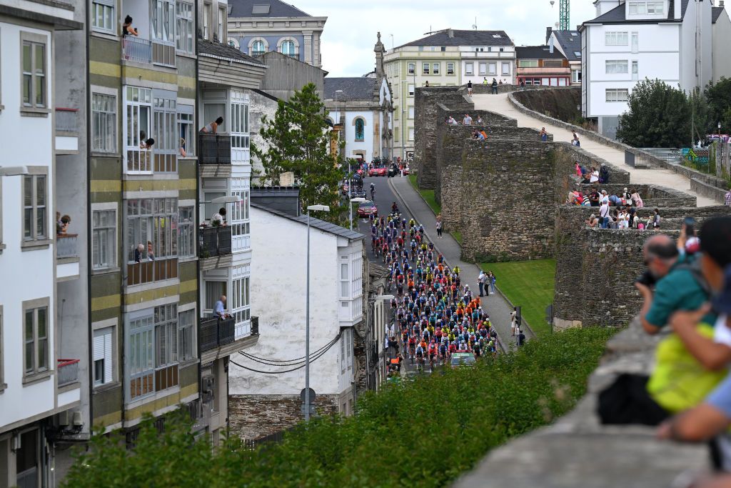 LUGO SPAIN AUGUST 30 A general view of the peloton passing the Lugo citywalls while fans cheer prior to the La Vuelta 79th Tour of Spain 2024 Stage 13 a 176km stage from Lugo to Puerto de Ancares 1659m UCIWT on August 30 2024 in Lugo Spain Photo by Tim de WaeleGetty Images