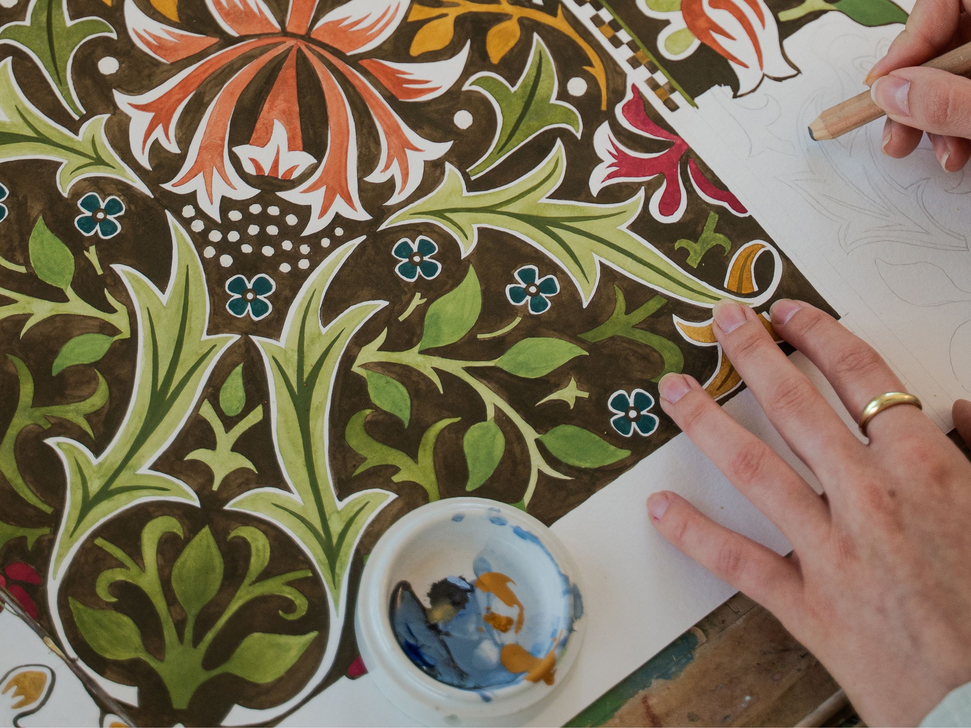 a person drawing and painting a morris and co pattern