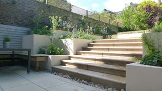 sloping garden ideas: stone garden steps linking two different levels in a modern garden space