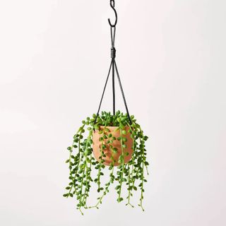 Artificial string of pearls houseplant hanging in a terracotta pot