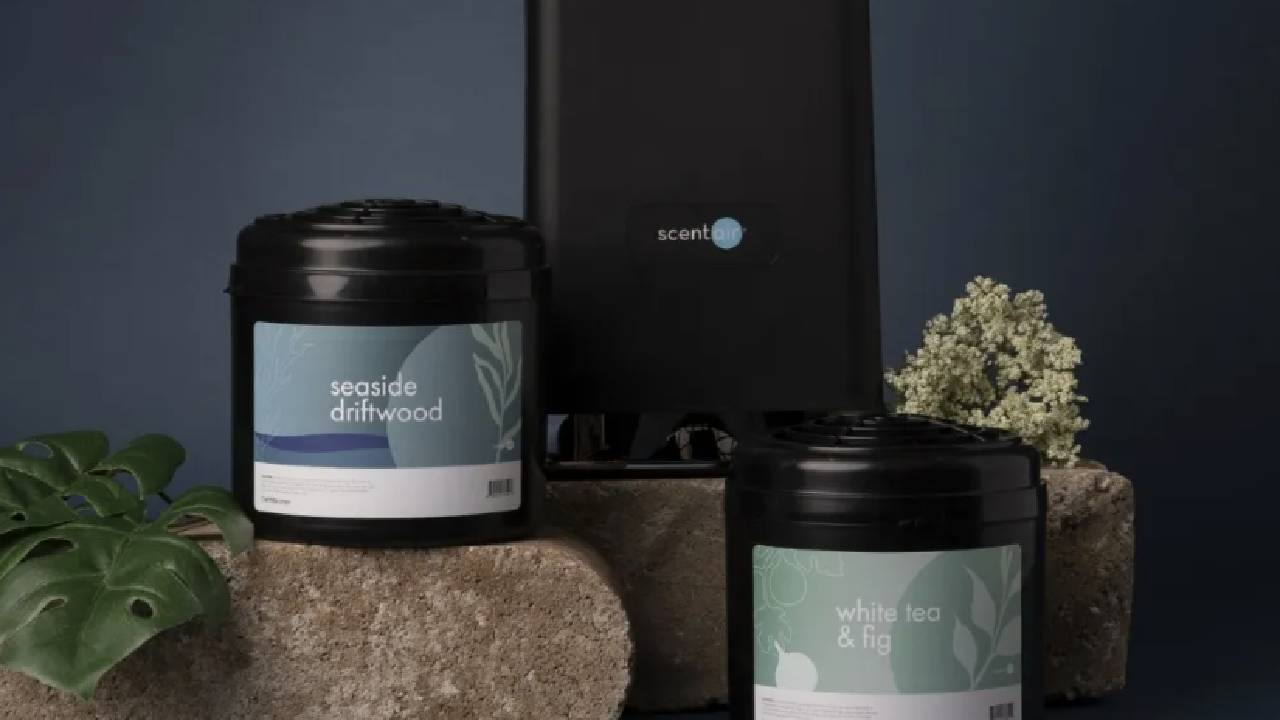 A black diffuser from ScentAir with two candles from ScentAir.