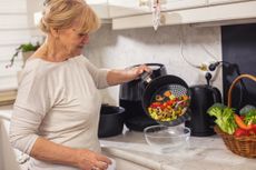 Woman using air fryer in the kitchen