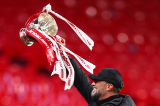 Jurgen Klopp celebrates with the League Cup trophy after Liverpool's win over Chelsea in the 2024 final.