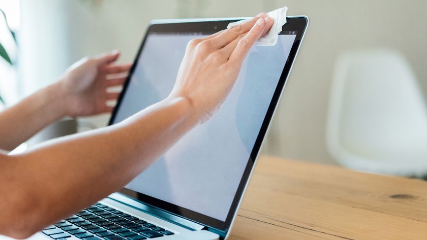 A person cleaning a laptop screen