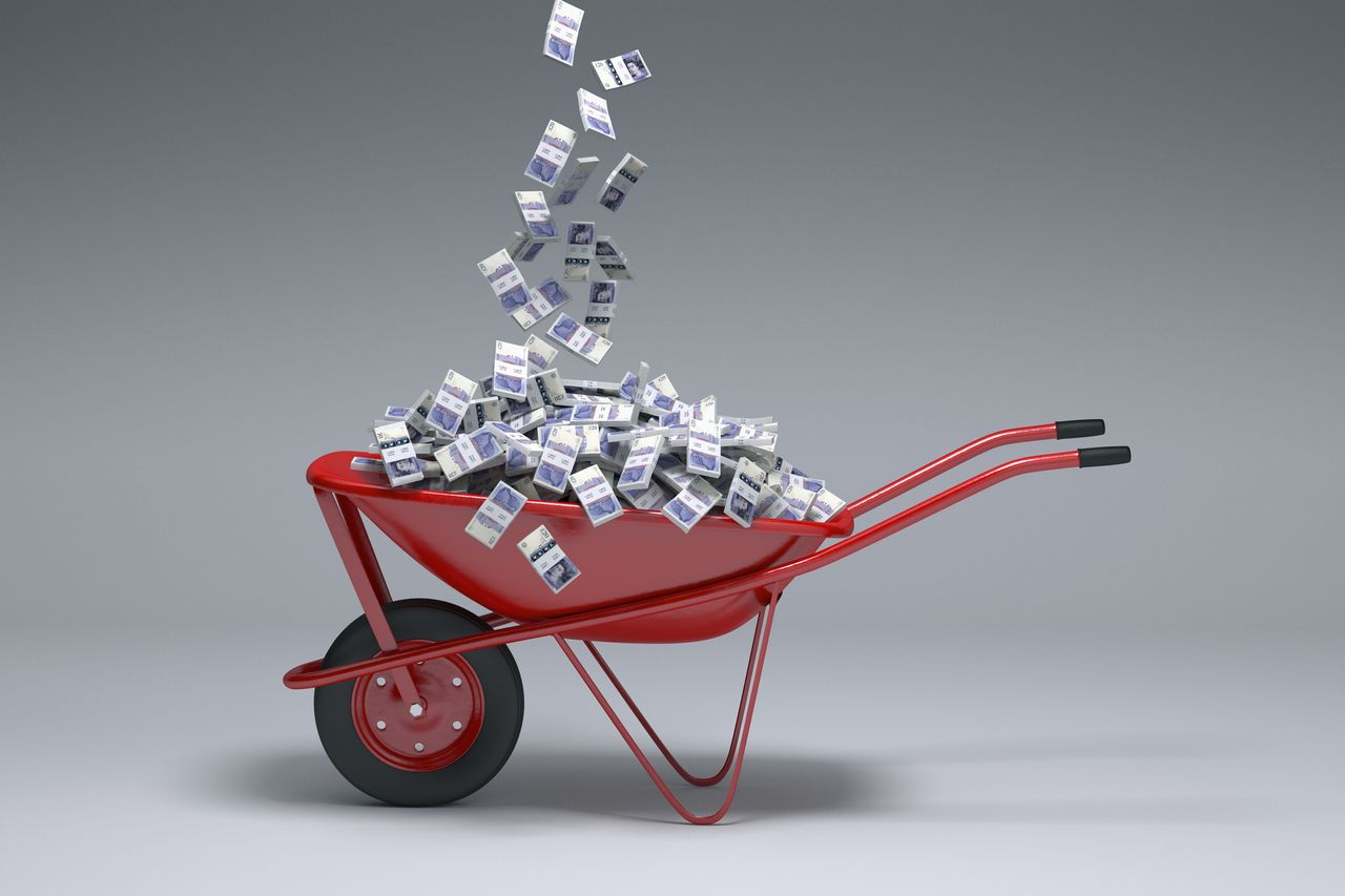 Money falling into a wheelbarrow