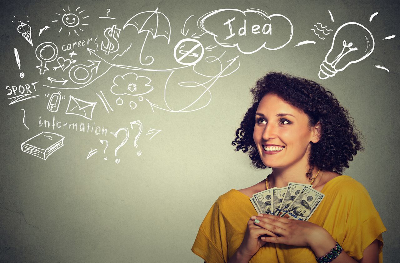 excited successful business woman holding money dollar bills