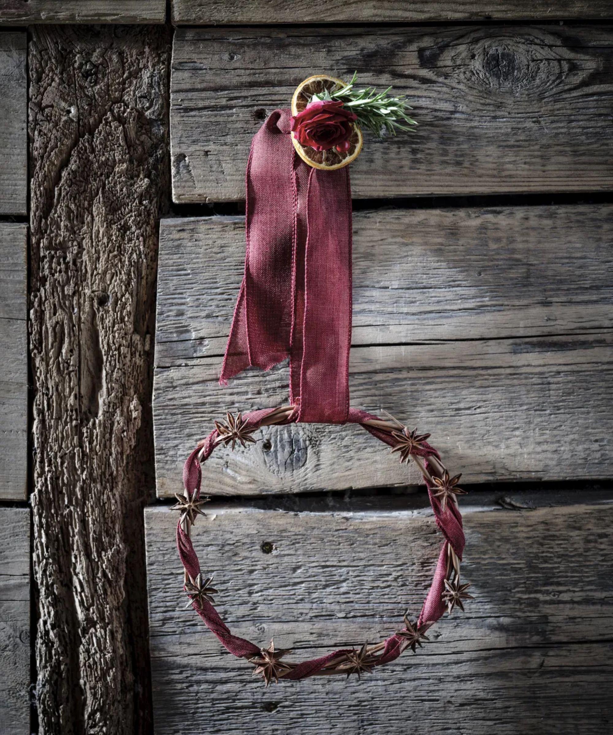 Willow wreath decorated with star anise and burgundy ribbon