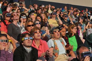 Spectators in special solar eclipse glasses stare at the sun during the annular solar eclipse on May 20, 2012.
