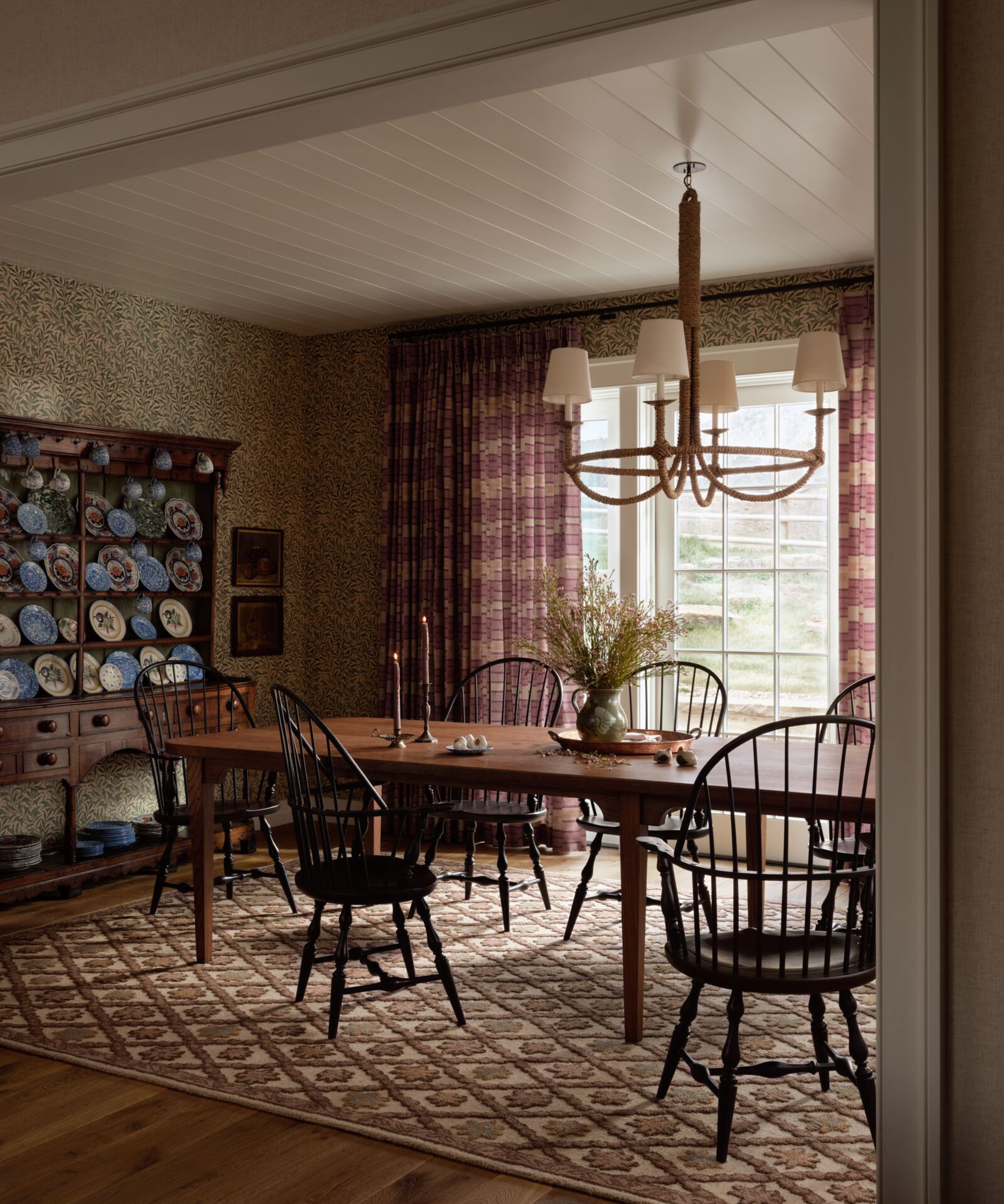 Earthy, collected living room featuring antique wooden furniture and a small-scale, folk-inspired rug designed by Heidi Caillier