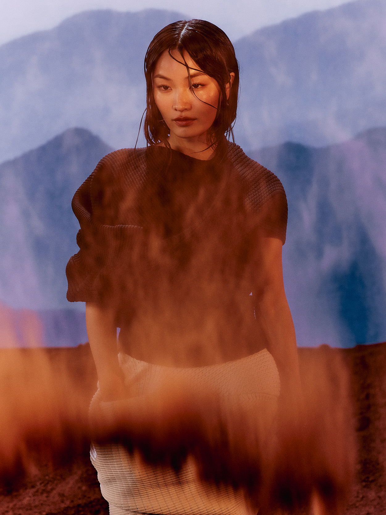 Anna Sawai stands against a mountain backdrop,
