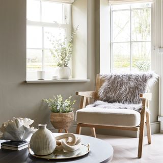 A living room with an accent chair draped with a faux sheepskin throw