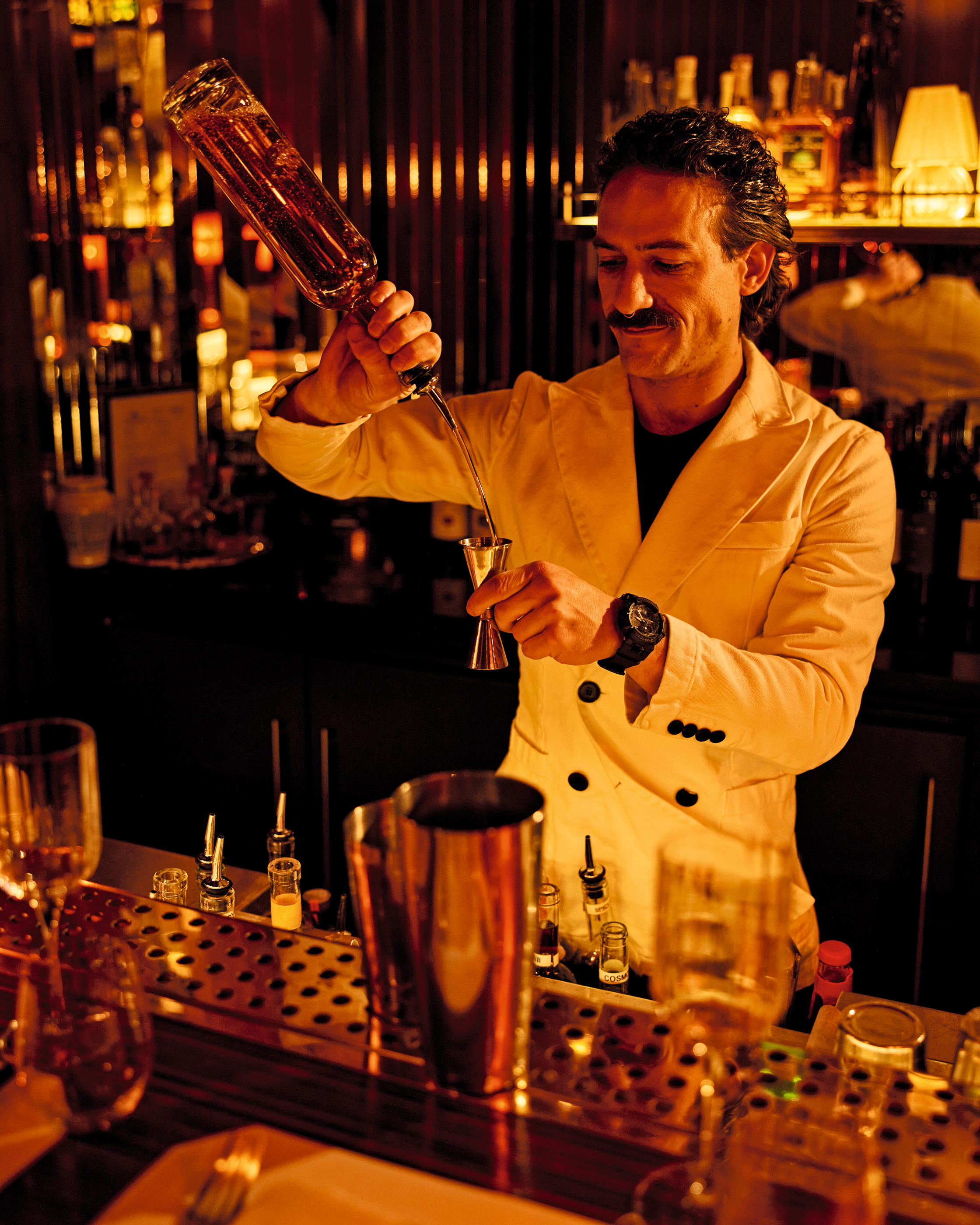 Man with moustache makes cocktail