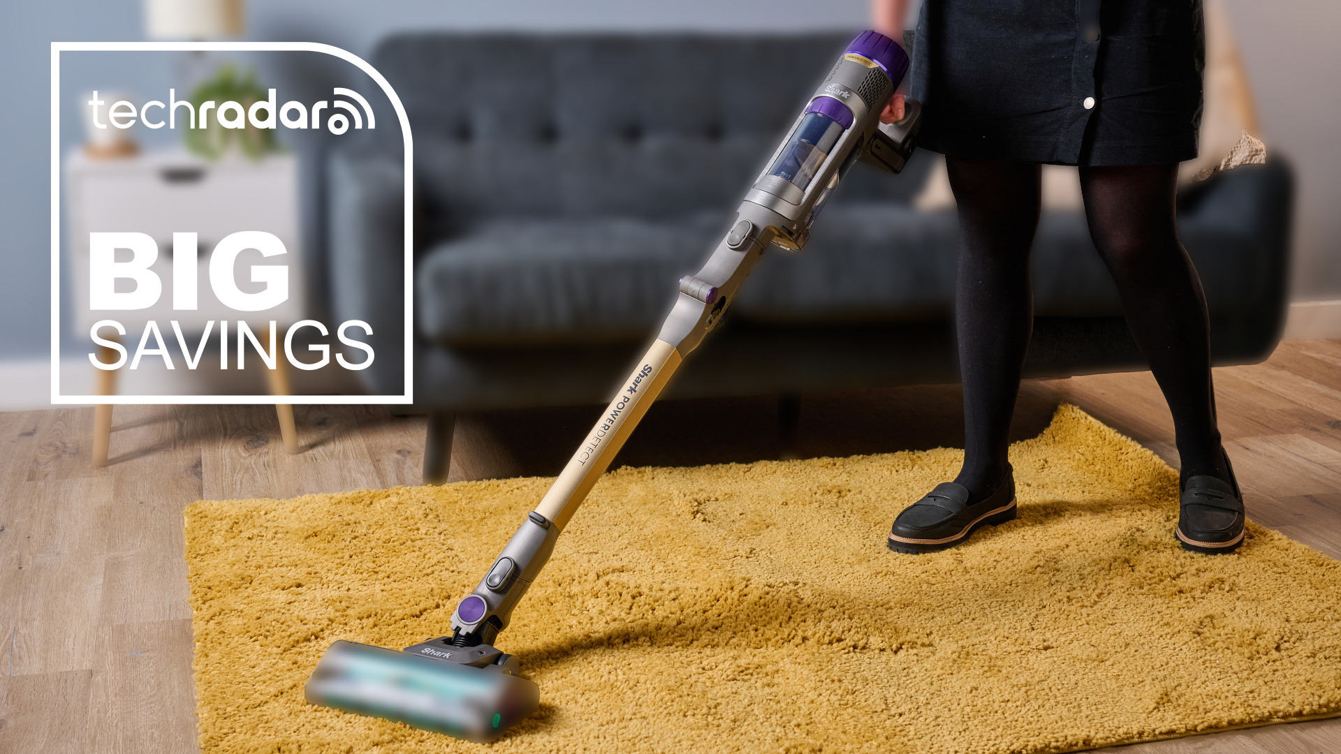 A woman using the Shark PowerDetect Cordless Vacuum cleaner on a yellow rug.